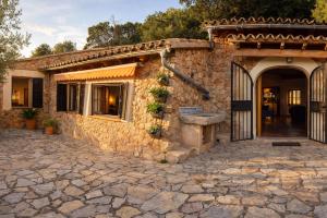 a stone house with a gate and a stone driveway at Cozy Chalet with Sea Views & Private Pool in Valldemossa