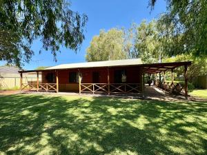 a small cabin with a grass yard in front of it at Macbeth Family Stay in Geographe