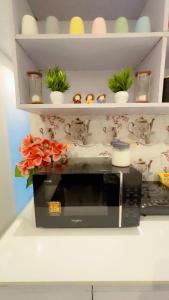 eine Mikrowelle auf einer Arbeitsplatte mit Blumen darauf in der Unterkunft Cherry blossom in Zirakpur