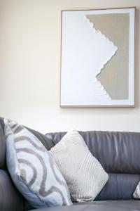 een bank met een kussen in de woonkamer bij The Lancefield Luxe in Glasgow