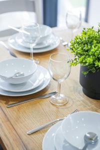 een houten tafel met witte borden en wijnglazen bij The Lancefield Luxe in Glasgow