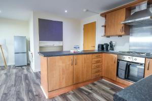 a kitchen with wooden cabinets and a counter top at The Lancefield Luxe in Glasgow