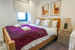 a bedroom with a large bed with two towels on it at The Lancefield Luxe in Glasgow