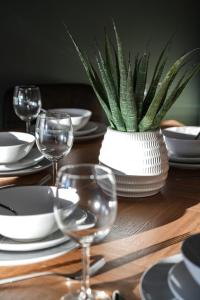 a wooden table with wine glasses and a potted plant at Cruachan House in Falkirk