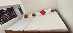 a bedroom with two beds with red and white pillows at Marlin Beachway Rooms- Baga Beach in Baga