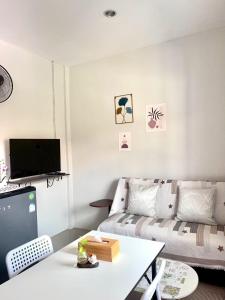 een woonkamer met een bank en een tafel bij Yada House s&s in Nai Yang Beach