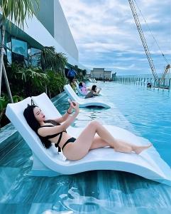头顿Center Point The Sóng Vung Tau - Infinity Pool的一名女子躺在水中的躺椅上