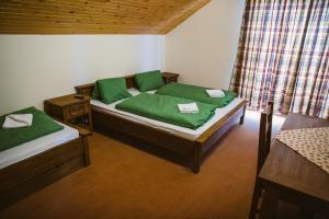 a bedroom with two beds with green sheets at Apartmány Zuzka in Zuberec