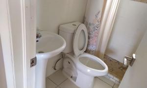 a white bathroom with a toilet and a sink at Claudette Guest House in Michelson +24 photos