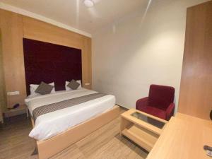 una camera da letto con un letto e una sedia rossa di Hotel N Regency ad Amritsar