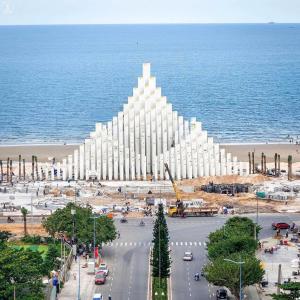 头顿Center Point The Sóng Vung Tau - Infinity Pool的一座大白色的建筑,位于海洋前