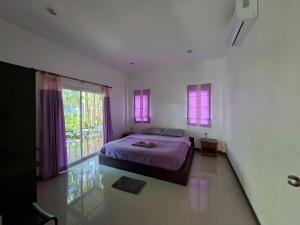 a bedroom with a bed and a large window at Little Purple House- AoNang in Ao Nang 