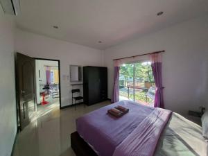 a bedroom with a bed with purple sheets and a window at Little Purple House- AoNang in Ao Nang  +55 photos
