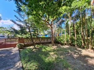 a yard with a fence and a tree at Little Purple House- AoNang in Ao Nang 