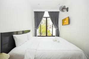 a bedroom with a large white bed with a window at Villa's Võ Thị Sáu Huế in Hue +41 photos