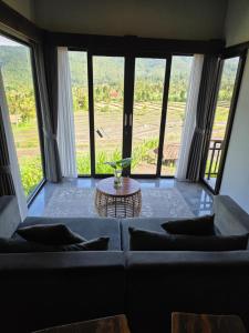 a living room with a couch and a table at MAYURA BALI VILLA in Munduk