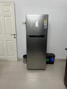 a stainless steel refrigerator in a room with a door at Zenaura Casa Villa 2 in Cochin