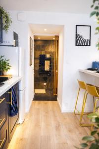 eine Küche mit Holzboden und einen Flur in der Unterkunft Bleu Chic Élégance Contemporaine - Proche Mer in Yffiniac