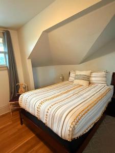 ein Schlafzimmer mit einem großen Bett mit gestreifter Bettwäsche in der Unterkunft Classic house in Eugene