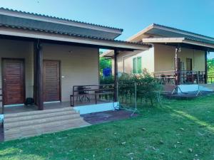 ein Haus mit einer Veranda mit Tischen und Stühlen in der Unterkunft Little Shark bungalow in Ban Bang Bao