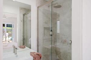 a bathroom with a glass shower and a sink at Ocean Haze - Putting Green, Firepit, Beach location in Mollymook +32 photos