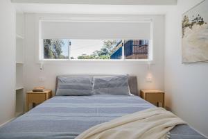 a bedroom with a bed and a window at Ocean Haze - Putting Green, Firepit, Beach location in Mollymook
