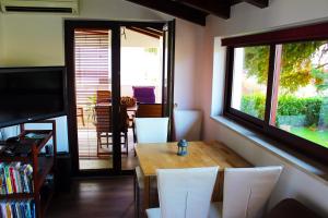 a dining room with a wooden table and white chairs at Apartment Pinia in Poreč