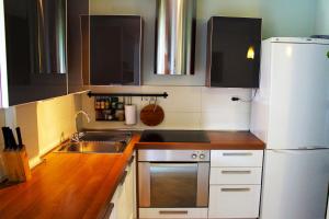 a kitchen with a sink and a white refrigerator at Apartment Pinia in Poreč