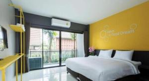 a bedroom with a large bed and a large window at Seven bee boutique hotel in Surin