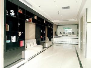 a living room with a white couch and a store at Xana Lite Hotel Tianjin National Exhibition Center Jinnan University Town in Tianjin