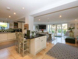 una cucina e un soggiorno con tavolo e sedie di Nant-yr-Rhedyn a Benllech