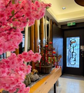 Un ramo de flores rosas sobre una mesa en una habitación. en Love's World B&B, en Jian