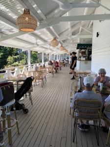 a deck with chairs and people sitting at tables at Reefside Escape Silkari Resort in Port Douglas