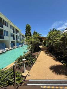 a walkway next to a pool at a hotel at Reefside Escape Silkari Resort in Port Douglas