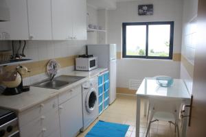 a kitchen with a sink and a microwave at Apartamento Mar e Sol in Ponta Delgada