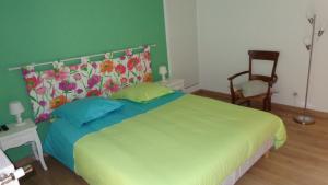 1 dormitorio con 1 cama grande y pared verde en Au clos des colombages en Athis