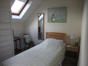 een slaapkamer met een bed, een bureau en een spiegel bij Woodway B&B in Blewbury