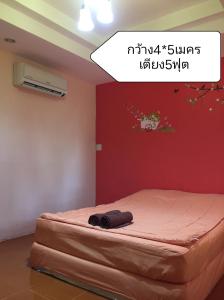 ein Bett in einem Zimmer mit einer roten Wand in der Unterkunft Baan I Mhok Suanphueng in Suan Phung + 67 Fotos