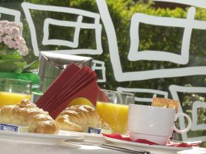 a table with a plate of pastries and cups of orange juice at Euro Hotel in Edolo