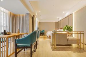 a hotel room with a bed and a table and chairs at Borrman Hotel Liuzhou Guizhong Avenue Liugao in Liuzhou