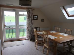 a dining room with a table and a large window at Woodway B&B in Blewbury