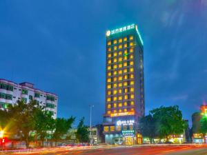 a lit up building on a city street at night at City Comfort Inn Zhanjiang Xuwen Port Wharf Passenger Station in Xuwen