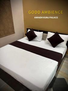 a bed with white sheets and pillows in a room at Awadh kunj palace in Ayodhya +14 photos