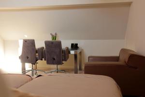 een kamer met 2 stoelen, een bank en een tafel bij Luxury Suites Arendshof in Antwerpen