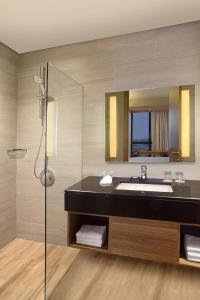 a bathroom with a sink and a mirror at BATIQA Hotel Lampung in Bandar Lampung