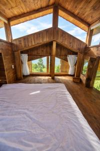 a large bed in a room with windows at Hồ Mây Homestay in Bảo Lâm