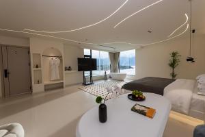 Dali Airport慕泊度假海景酒店的一间带床的卧室和一间带桌子的客厅