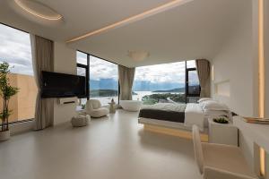 Dali Airport慕泊度假海景酒店的一间卧室设有一张床、一台电视和大窗户