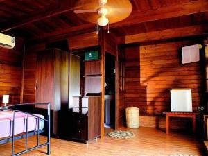 a bedroom with a bed and a wooden wall at Ma-Oya Retreat in Andiramada