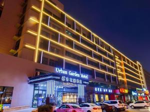a building with cars parked in front of it at Urban Garden Hotel Chengyang District Government Liuting Airport in Qingdao